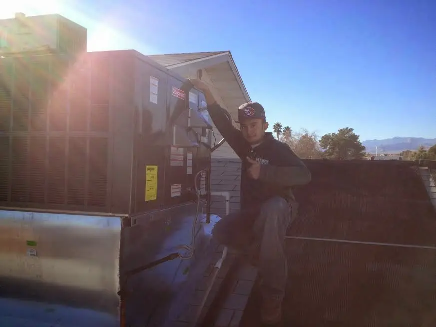 HVAC technician performing AC Tune-Up on a rooftop unit in Salem